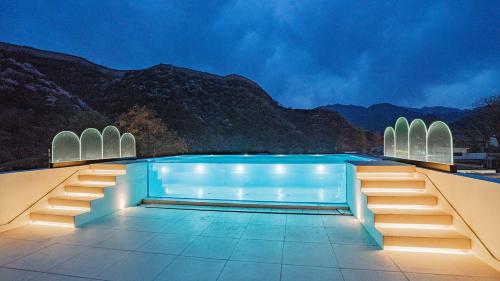una piscina con vistas a las montañas en Beifei Garden--Majestic Great Wall View Exclusive Hot Spring Villa，5 minutes' walk to Badaling Shuiguan Great Wall，Rooftop Infinity Pool with Panoramic Great Wall Views，Free Coffee, Laundry, en Xibozi
