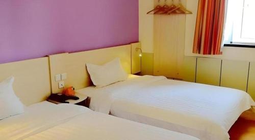 a hotel room with two beds and a window at 7 Days Inn Nanjing Xinjiekou Changfu Street Metro Station in Nanjing