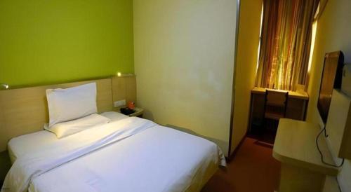 a bedroom with a white bed and a green wall at 7 Days Inn Changzhou Yancheng Technology Metro Station in Changzhou