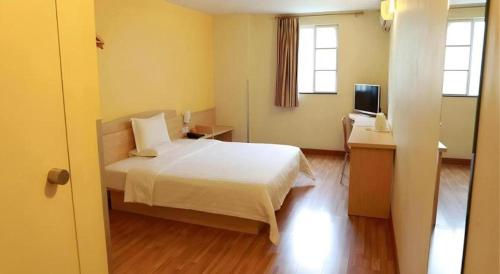 a bedroom with a bed and a desk and a television at 7 Days Inn Changzhou Yancheng Technology Metro Station in Changzhou