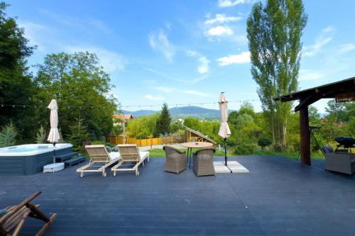 a patio with chairs and a table and umbrellas at Friday Inn Igloo - Intimitate, Jacuzzi, Natura, Priveliste & Iaz - Escapadă romantică premium la o oră de Bucuresti - Eco Friendly Micro-Resort in Comarnic