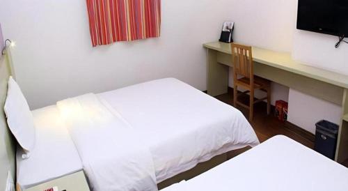 a room with two beds and a desk with a computer at 7 Days Inn Guilin Beiji Plaza Yushan Garden in Guilin