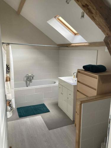 a bathroom with a bath tub and a sink at Maison du bonheur SPA in Neuvic