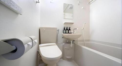 a white bathroom with a toilet and a sink at La'gent Inn Kesennuma in Higashi-hachimammae