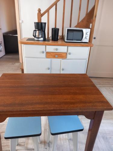 a kitchen with a wooden table and a microwave at Maison du bonheur spa in Neuvic