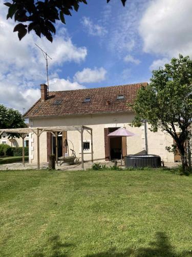 a white house with a large yard in front of it at Maison du bonheur spa in Neuvic