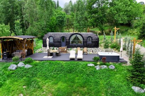 a tiny house in the middle of a yard at Friday Inn Igloo - Intimitate, Jacuzzi, Natura, Priveliste & Iaz - Escapadă romantică premium la o oră de Bucuresti - Eco Friendly Micro-Resort in Comarnic