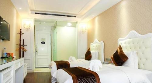 a bedroom with two white beds and a mirror at GreenTree Alliance Anhui Hefei South Passenger Station South High Speed Railway Station Hotel in Hefei