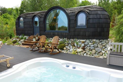 a tiny house with a tub in the yard at Friday Inn Igloo - Intimitate, Jacuzzi, Natura, Priveliste & Iaz - Escapadă romantică premium la o oră de Bucuresti - Eco Friendly Micro-Resort in Comarnic