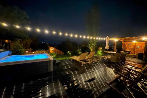 a backyard at night with a hot tub and lights at Friday Inn Igloo - Intimitate, Jacuzzi, Natura, Priveliste & Iaz - Escapadă romantică premium la o oră de Bucuresti - Eco Friendly Micro-Resort in Comarnic