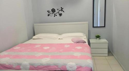 a bedroom with a bed with a pink and white comforter at The Second Room in Ranau