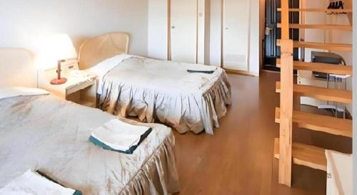 a room with two beds and a stair case at Hotel Bellreef Otsuki in Otsuki