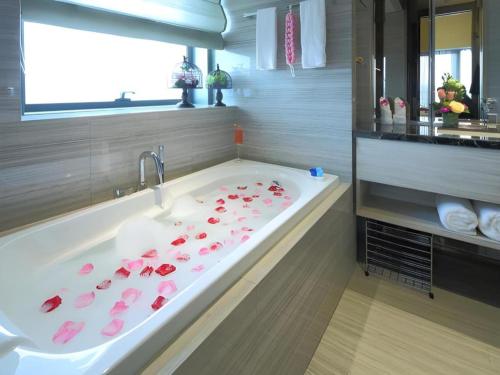 a bathroom with a bath tub with pink roses on it at Huafa Executive Apartment Hotel Zhuhai in Zhuhai