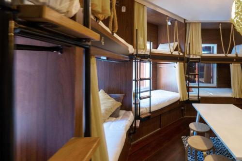 a room with two bunk beds and a table at OYO 895 The Onion Hostel in Bangkok