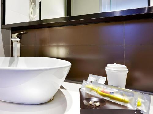 a bathroom with a sink and a bowl on a counter at 7 Days Premium Xi'an Dayan Tower Xiaozhai Metro Station in Xi'an