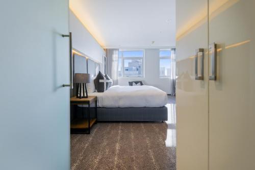 a bedroom with a bed and a large window at The Capital 15 on Orange Hotel & Spa in Cape Town