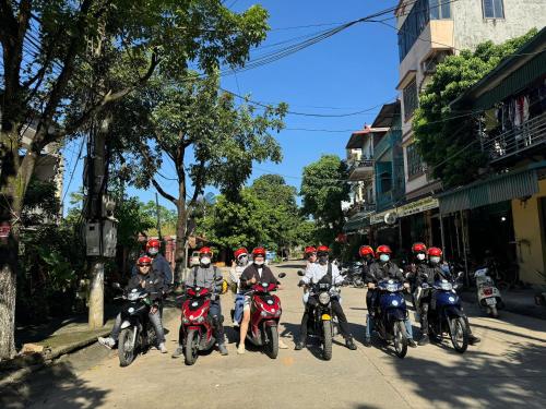 a group of people riding motorcycles down a street at Cao Bang Eco Homestay in Cao Bằng