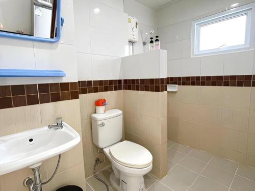 a bathroom with a toilet and a sink at Rueangrat Hotel in Ranong