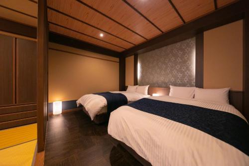 a bedroom with two beds and a wall at Hotel Higashidate in Yamanouchi