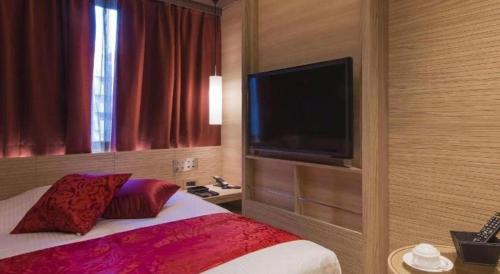 a hotel room with a bed and a flat screen tv at Hotel Ann Tsukiji in Tokyo