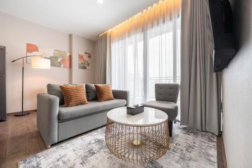 una sala de estar con un sofá y una mesa en The Rich Grand Residence Sukhumvit, en Bangkok