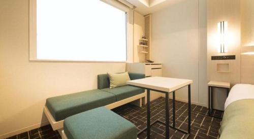 a room with a bench and a table and a window at Hotel Yaenomidori Tokyo in Tokyo