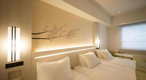 a bedroom with two white beds and a painting on the wall at Hotel Yaenomidori Tokyo in Tokyo