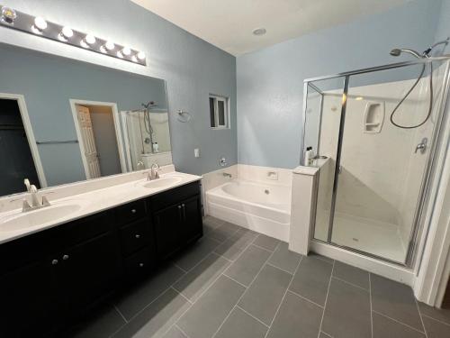 a bathroom with a tub and a sink and a shower at Family Friendly Contemporary House with Pool in Las Vegas