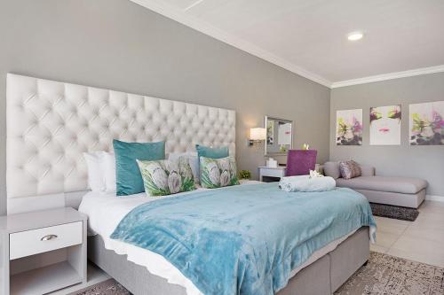 a bedroom with a large bed with a blue blanket at 2 On Lismore Guesthouse in Tokai