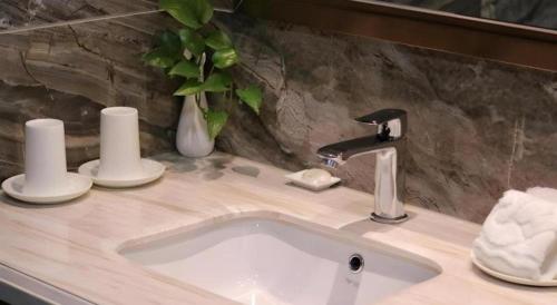a bathroom sink with a faucet on a counter at Chaozhou Hotel in Chaozhou