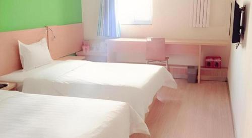 a small room with two beds and a window at 7 Days Inn West Gate of Taiyuan University of Technology in Taiyuan