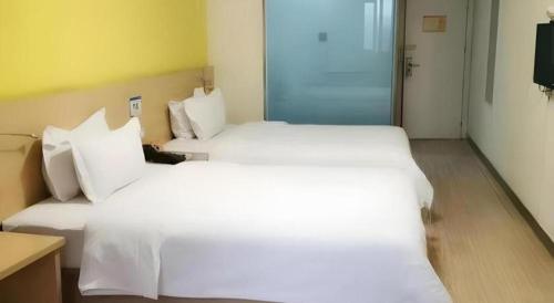 a large white bed in a hotel room at 7 Days Inn West Gate of Taiyuan University of Technology in Taiyuan