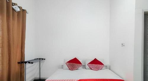 a bedroom with a bed with two red pillows at OYO 91886 Bfs Homestay Syariah in Jambi