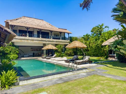 a villa with a swimming pool and a resort at Villa Blubambu in Seminyak