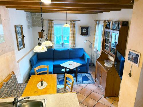 a living room with a blue couch and a table at Emma Häusle in Sommerhausen