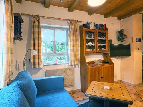 a living room with a blue couch and a window at Emma Häusle in Sommerhausen