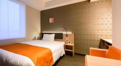 a hotel room with a bed with an orange blanket at KEIKYU EX INN Haneda Innovation City 2 minutes walk from HICity Exit of Tenkubashi Station in Tokyo