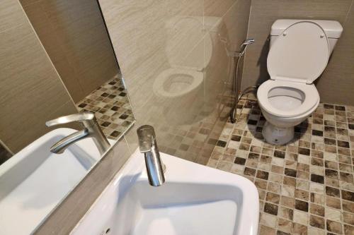 a small bathroom with a toilet and a sink at Station 203 Hotel in Bangkok