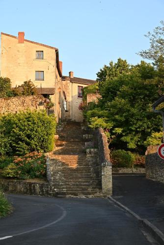 an old stone building on a street next to a road at Le petit coin caché in Montreuil-Bellay