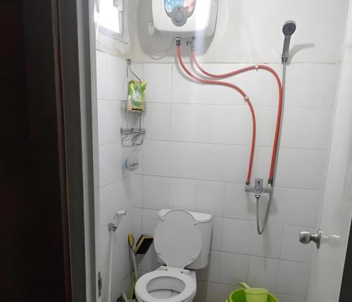 a small bathroom with a toilet and a shower at OYO Living 3091 Apt The Suites Metro By Ananda in Bandung