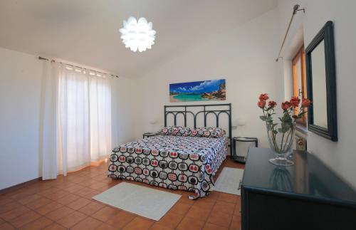 een slaapkamer met een bed en een vaas met bloemen bij Casa Guglielmo in Viareggio