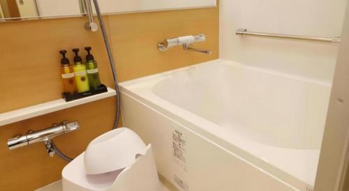 a bathroom with a toilet with bottles of wine at KEIKYU EX INN Tokyo Nihombashi in Tokyo