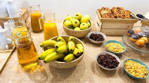 a table with bowls of fruit and bottles of juice at VTZ Hotel El Príncipe in Zaragoza