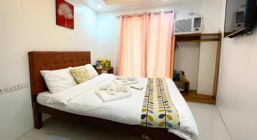 a bedroom with a bed with two stuffed animals on it at Pilot Hotel in Alaminos