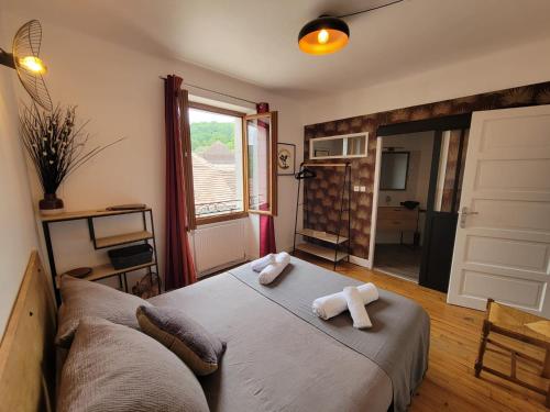 a bedroom with a bed with towels on it at L'Embellie in Gagnac-sur-Cère
