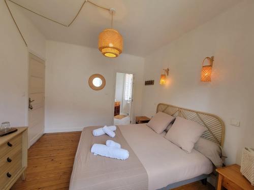 a bedroom with a bed with two towels on it at L'Embellie in Gagnac-sur-Cère
