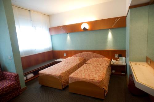 a hotel room with a bed and a chair at Brunelleschi Hotel in Milan