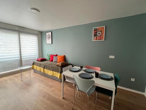 a bedroom with a bed and a table and chairs at PERLE HDG Tout Confort in La Courneuve