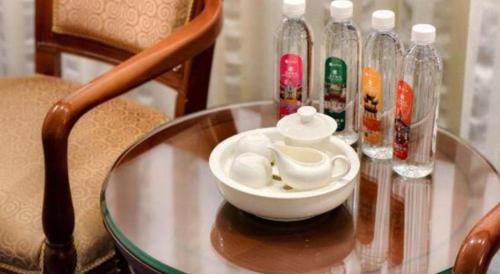a glass table with a bowl and bottles on it at Quanzhou Hotel in Quanzhou