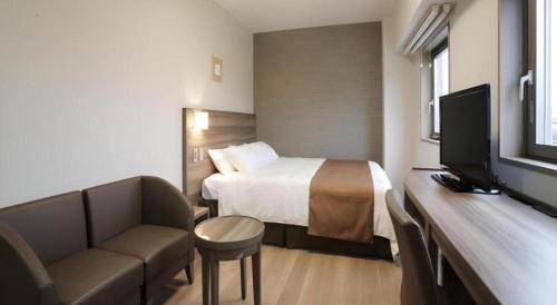 a hotel room with a bed and a television at Hotel Sunoak Kashiwanoha in Kashiwa